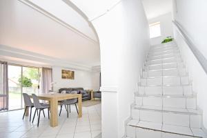 een witte trap in een woonkamer met een tafel en stoelen bij Sandton Elite Stay in Sandton