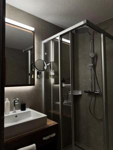 ein Badezimmer mit Waschbecken und Dusche in der Unterkunft Hotel Central in Ischgl