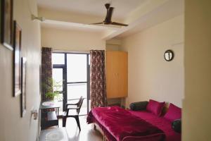 a bedroom with a bed and a table and a window at LVMR RIDERS REST Homestay in Kulu