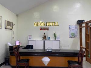 een restaurant met een bar en 2 stoelen bij Palette Gems Hotel and Conference Center in Antipolo