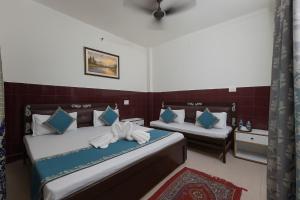 ein Schlafzimmer mit zwei Betten mit blauen und weißen Kissen in der Unterkunft The Ayodhya Ji Palace in Ayodhya