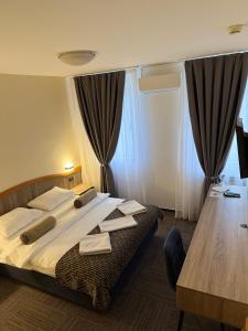 een slaapkamer met een groot bed met handdoeken erop bij Hotel Previla in Sarajevo +20 foto's