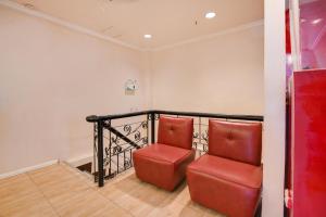 due sedie rosse appoggiate accanto a una ringhiera in una stanza di Zia Suites a Bugo