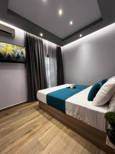 a bedroom with a large bed with blue pillows at Morfeas apartments in Sarti
