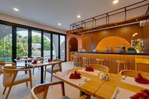 a restaurant with tables and chairs and a bar at Bhatara Villa Sanur in Sanur