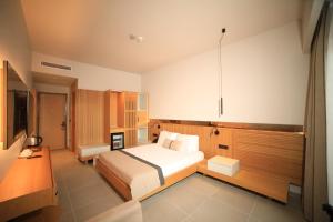 una camera da letto con un letto e una televisione di Blue Inn Hotel a Gökçeada Altre 3 foto