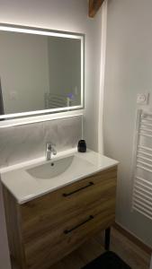 een badkamer met een witte wastafel en een spiegel bij Maison calme in Pleumeleuc