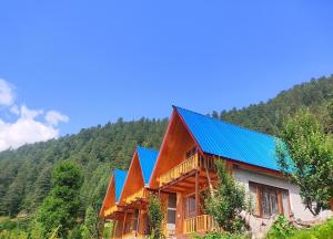 a wooden house with a blue roof at A-Frame Cabins in Sainj