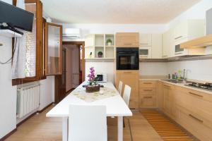 a white kitchen with a white table and chairs at Venice Biennale Garibaldi in Venice