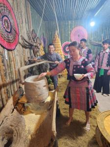 Een vrouw staat voor een mortier. bij Lộc Phát hotel Mộc Châu in Bả Duộc
