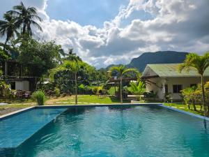 a swimming pool in front of a house at Masayana in El Nido