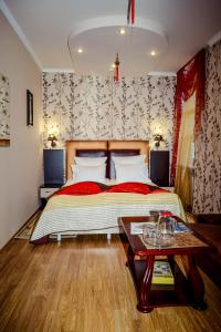 a bedroom with a large bed and a table at Hotel Atlantida in Kislovodsk