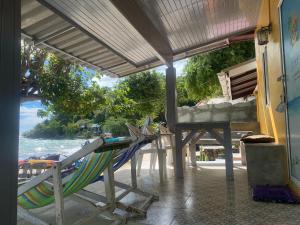 a group of chairs and a table on a beach at Banpu Beach Ao Lung Dam,Koh Samet in Ao Phutsa