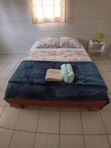 a bed with a pair of slippers sitting on it at La Villa Ti'Lau in Saint-Laurent du Maroni +8 photos