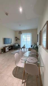 a living room with a glass table and chairs at Dar Al Noor Apartment in Dubai