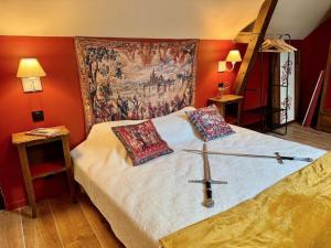a bedroom with a cross on a bed with a tapestry at maison climatisée à thème médiéval avec baignoire balnéothérapie in Sens