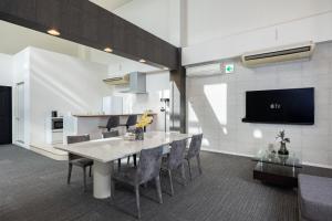 a dining room with a table and chairs and a tv at Bijou Suites AI PREMIUM in Osaka