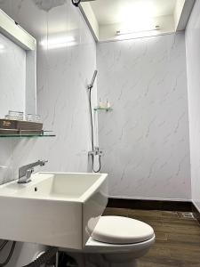 a white bathroom with a sink and a toilet at OThuy's House in Hue in Hue +51 photos