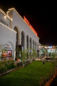 een hotel met een gazon ervoor 's nachts bij Hotel Highway Prince Behror in Behror