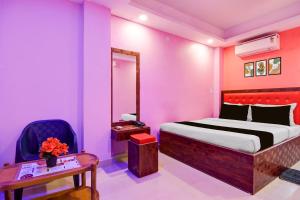 een slaapkamer met een bed, een tafel en een stoel bij Hotel O Golden Star in Ballygunge
