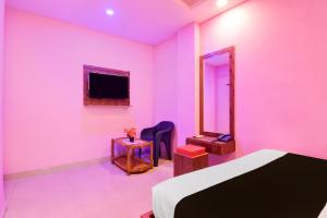 een roze kamer met een bed en een spiegel bij Hotel O Golden Star in Ballygunge