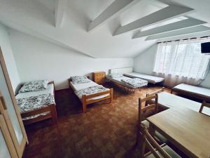 une chambre avec trois lits et une table dans l'établissement Jabłoń w Ogrodzie, à Częstochowa