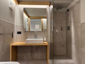 une salle de bain avec lavabo et douche dans l'établissement Hotel Galli's - Centro, à Livigno 234 autres photos