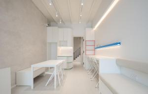 a laboratory with white tables and stools in a room at Bedd Hostel in Bangkok