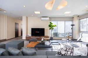 a living room with a couch and a tv at Bijou Suites AI PREMIUM in Osaka