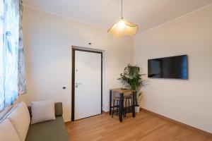 een woonkamer met een bank en een flatscreen-tv bij Gioia Apartment in Sabaudia