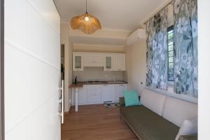 een woonkamer met een bank en een keuken bij Gioia Apartment in Sabaudia