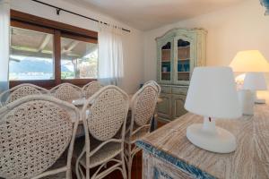 een kamer met stoelen en een tafel met een lamp bij Appartamento Baia Caddinas fronte mare in Golfo Aranci +34 foto's