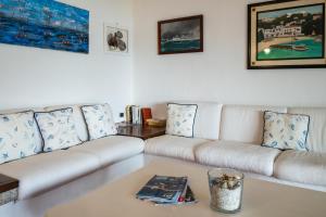 een woonkamer met een witte bank en een tafel bij Appartamento Baia Caddinas fronte mare in Golfo Aranci