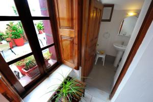 porta aperta per un bagno con lavandino di Kavalari Hotel - Adults Only a Firà