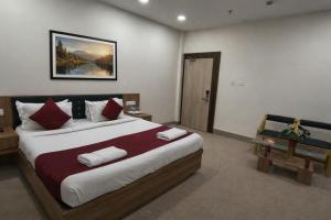 ein Schlafzimmer mit einem großen Bett mit roten und weißen Kissen in der Unterkunft Hotel Opulence Kalinga in Mancheshwar