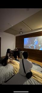 a group of people sitting on beds watching a tv at OThuy's House in Hue in Hue