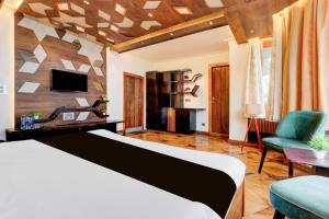 een slaapkamer met een bed, een bureau en een tv bij Hotel O Siris Luxury Cottage Amatra Dunsvirk Court in Mussoorie