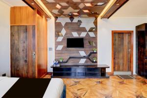 een slaapkamer met een bed en een tv aan de muur bij Hotel O Siris Luxury Cottage Amatra Dunsvirk Court in Mussoorie
