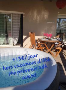 une baignoire assise à côté d'un patio avec une table dans l'établissement Les gardiens de la vallée, à Figeac