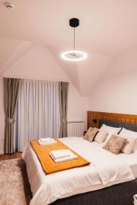 een slaapkamer met een groot bed met twee handdoeken erop bij Hotel Nordik in Motički Gaj