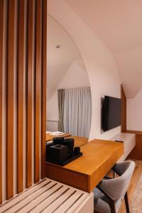 een kamer met een bureau, een televisie en een stoel bij Hotel Nordik in Motički Gaj +20 foto's