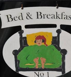 une enseigne de chambre d'hôtes avec la photo d'une fille dans l'établissement Bed and Breakfast Bergzyt - im Ski und Wandergebiet, à Linthal