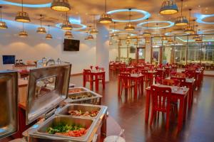 ein Restaurant mit roten Tischen und Stühlen und einem Buffet in der Unterkunft Season Paradise in Thulusdhoo