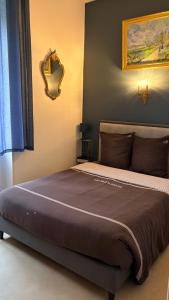 een slaapkamer met een groot bed met een spiegel aan de muur bij La Garçonnière II in Charolles