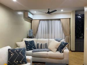 a living room with a couch and a ceiling fan at Masaki Comfort III Dar es Salaam Tanzania in Dar es Salaam