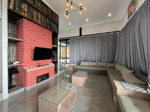 ein Wohnzimmer mit einem Sofa und einer roten Backsteinwand in der Unterkunft Anemos Resort By Tamastu in Pasirpogor