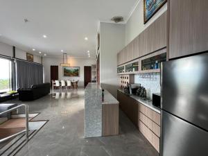 a kitchen with a refrigerator and a living room at Anemos Resort By Tamastu in Pasirpogor