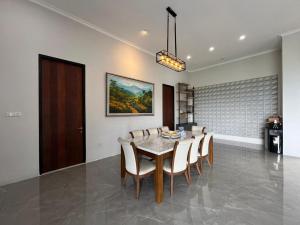 ein Esszimmer mit Tisch und Stühlen in der Unterkunft Anemos Resort By Tamastu in Pasirpogor