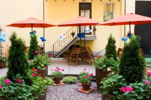 a patio with umbrellas and flowers in pots at Maestro Hostel in Saint Petersburg