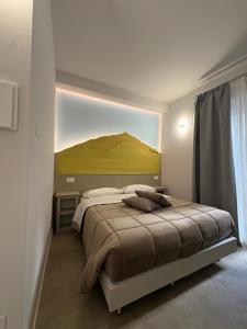 a bedroom with a bed with a large painting on the wall at Quattro Vette in Norcia